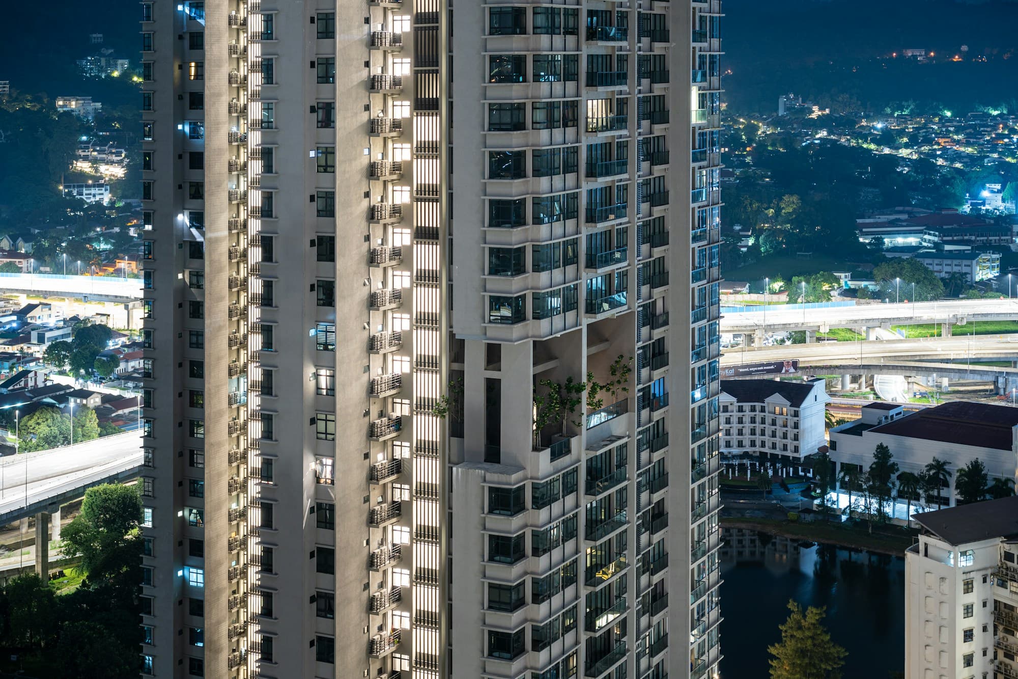 Modern condominium tower at dusk — example of the kind of listing realtors publish on RumahProp